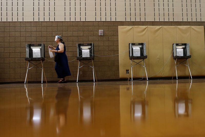 © Reuters. FILE PHOTO: A woman wearing a face shield finishes her ballot during the primary election in Minneapolis, Minnesota, U.S. August 11, 2020.  REUTERS/Nicole Neri