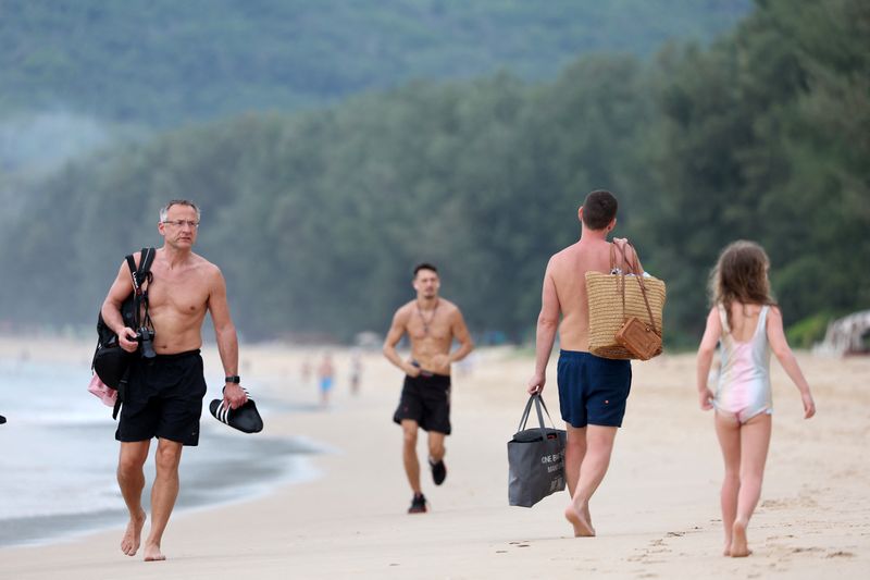 &copy; Reuters. FILE PHOTO: Tourists walk at the beach in Phuket, Thailand March 8, 2022. REUTERS/Jorge Silva/File Photo