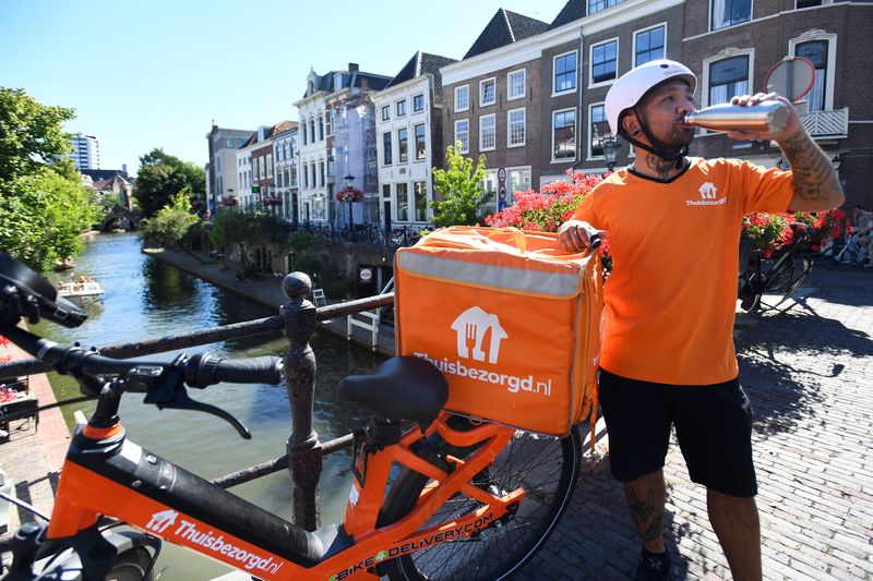 &copy; Reuters. Edward James Morta, repartidor de la empresa Takeaway, bebe agua durante una ola de calor en Utrecht, Países Bajos, el 10 de agosto de 2022. REUTERS/Piroschka van de Wouw