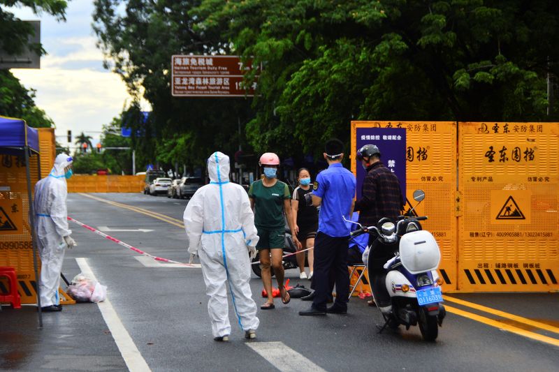 &copy; Reuters. FILE PHOTO: A delivery courier places food near a barricade at an entrance to a residential compound, amid lockdown measures to curb the coronavirus disease (COVID-19) outbreak in Sanya, Hainan province, China August 8, 2022.  China Daily via REUTERS