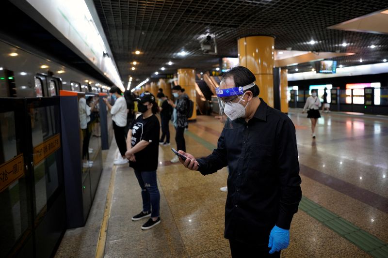 &copy; Reuters. FILE PHOTO: A man wearing protective gear checks his mobile phone at a subway station, after the lockdown placed to curb the coronavirus disease (COVID-19) outbreak was lifted in Shanghai, China June 2, 2022. REUTERS/Aly Song