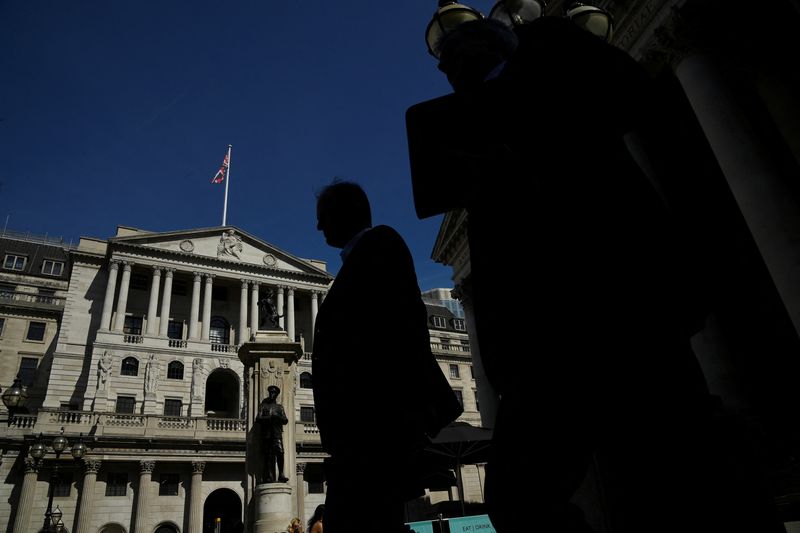 © Reuters. رجلان يمران أمام بنك إنجلترا في لندن يوم الثامن من أغسطس آب 2022. تصوير: توبي ميلفيل - رويترز