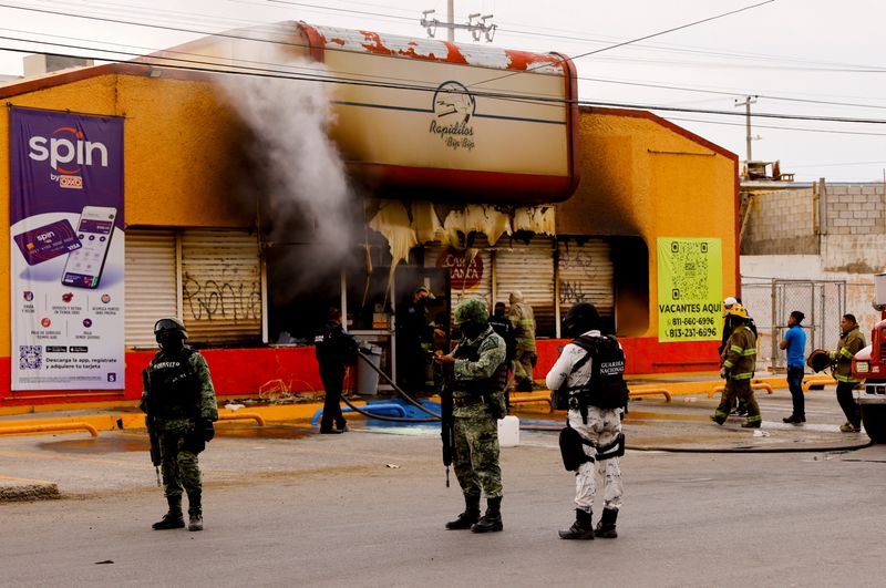 &copy; Reuters. Fuerzas de seguridad permanecen frente a una tienda que fue quemada por atacantes desconocidos, en un ataque simultáneo de incendios en diferentes partes de la ciudad, según medios locales, en Ciudad Juárez, México. 1de agosto, 022. REUTERS/Jose Luis 