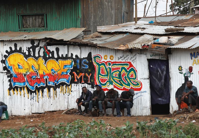 © Reuters. People sit next to a mural advocating for peace after the general election conducted by the Independent Electoral and Boundaries Commission (IEBC) in Kibera slums Nairobi, Kenya August 12, 2022. REUTERS/Monicah Mwangi