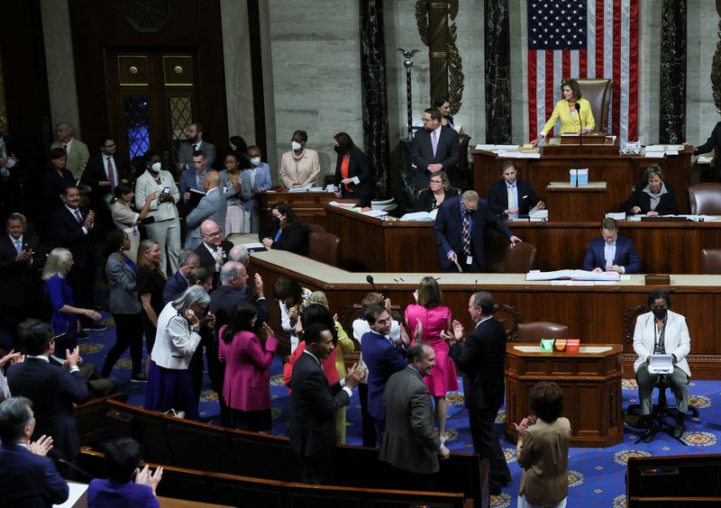 © Reuters. Democratic members of the U.S. House of Representatives applaud and celebrate as Speaker of the House Nancy Pelosi (D-CA) lays down her gavel after the House passed H.R. 6376, the 