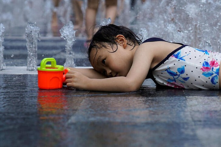 &copy; Reuters. Imagen de archivo de una niña refrescándose en una fuente en medio de la ola de calor en Shanghái, China. 23 julio 2022. REUTERS/Aly Song