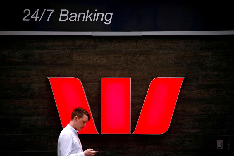 &copy; Reuters. FILE PHOTO: A pedestrian looks at his phone as he walks past a logo for Australia's Westpac Banking Corp located outside a branch in central Sydney, Australia, November 5, 2018.   REUTERS/David Gray/File Photo/File Photo