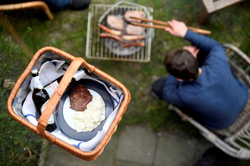 &copy; Reuters. FILE PHOTO: A basket filled with beers and food from a downstairs barbecue, is lifted up with a string to neighbors, during the spread of the coronavirus disease (COVID-19) in Hamburg, Germany March 28, 2020. REUTERS/Fabian Bimmer