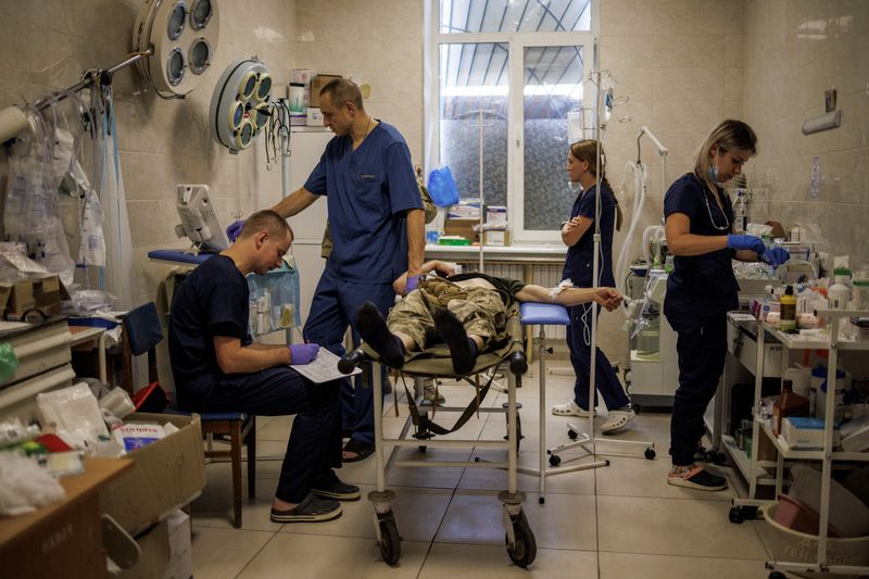&copy; Reuters. عاملون في القطاع الطبي يعالجون جندي أوكراني في مستشفى عسكري في دونيتسك يوم التاسع من أغسطس آب 2022. تصوير: ألكيس قنسطنطينديس - رويترز