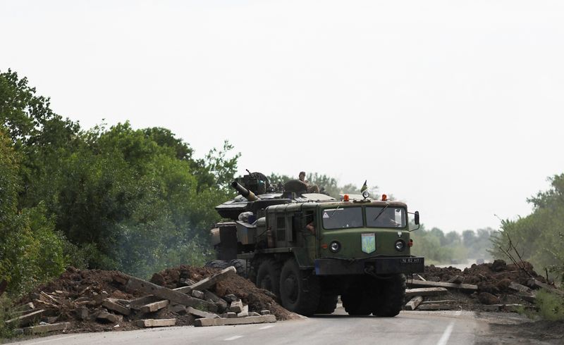 © Reuters. A Ukrainian serviceman gestures on a tank, as it is towed away by a military truck near Bakhmut, as Russia's invasion of Ukraine continues, in Donetsk region, Ukraine August 15, 2022. REUTERS/Nacho Doce