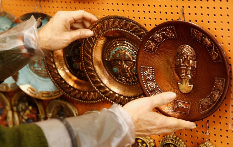 &copy; Reuters. A vendor shows copper plates displayed for sale at a handicraft shop in Lima, Peru, October 25, 2017. REUTERS/Mariana Bazo/File Photo