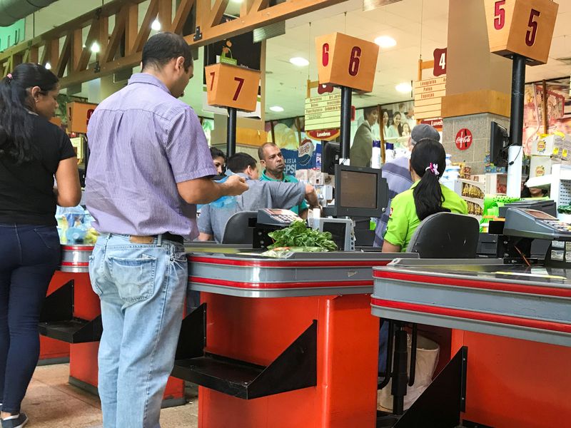 &copy; Reuters. FILE PHOTO: People queue to pay for food at the cashier of a supermarket in Caracas, Venezuela November 7, 2018. REUTERS/Marco Bello