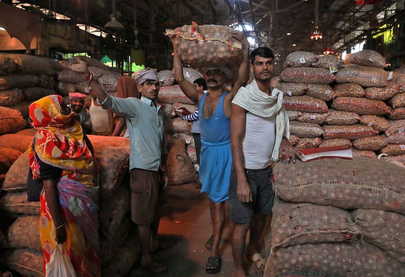 &copy; Reuters. FILE PHOTO: A labourer carries a sack of onions at a wholesale market in Kolkata, India, December 14, 2021. REUTERS/Rupak De Chowdhuri