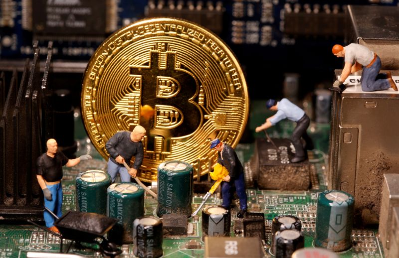 &copy; Reuters. FILE PHOTO: A representation of virtual currency Bitcoin and small toy figures are placed on computer motherboard in this illustration taken January 7, 2021. Picture is taken January 7, 2021. REUTERS/Dado Ruvic/File Photo