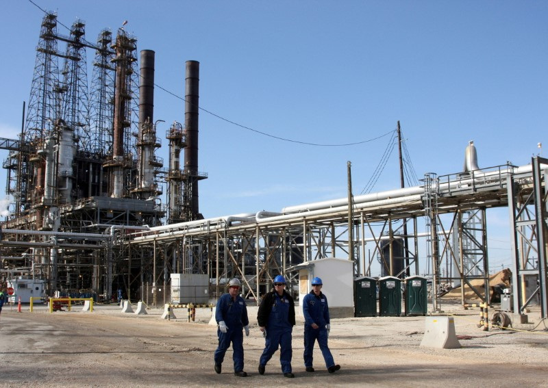&copy; Reuters. Tre operai presso una raffineria petrolifera a Houston, Texas. REUTERS/Donna Carson
