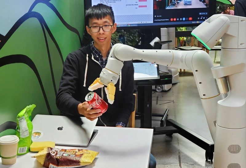 &copy; Reuters. El científico de investigación de Google, Fei Xia, acepta una lata de Coca-Cola de un robot durante una demostración de la tecnología de IA en una cocina de la compañía en Mountain View, California, Estados Unidos. 11 de agosto de 2022.  REUTERS/Par