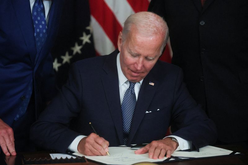 Biden signs inflation act, hands pen to Manchin
