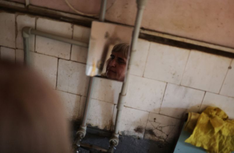 &copy; Reuters. Tatyana Medvedenko, de 48 años, una persona con discapacidad visual se refleja en un espejo mientras lava los platos en la cocina comunitaria de un albergue para ciegos, en medio de la invasión rusa de Ucrania, en Jarkov 

Ago 10, 2022. REUTERS/Nacho Do