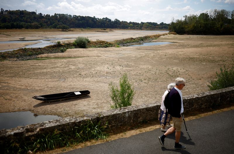 &copy; Reuters. People walk near a bank of the Loire River as historical drought hits France, in Loireauxence, France, August 16, 2022. REUTERS/Stephane Mahe     