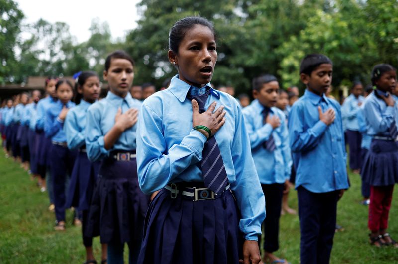 &copy; Reuters. Parwati Sunar, 27, sings the national anthem of Nepal while attending an assembly at Jeevan Jyoti secondary school in Punarbas, Kanchanpur district, southwest Nepal, August 7, 2022. Parwati attends the same school as her eldest son, Resham, after returnin