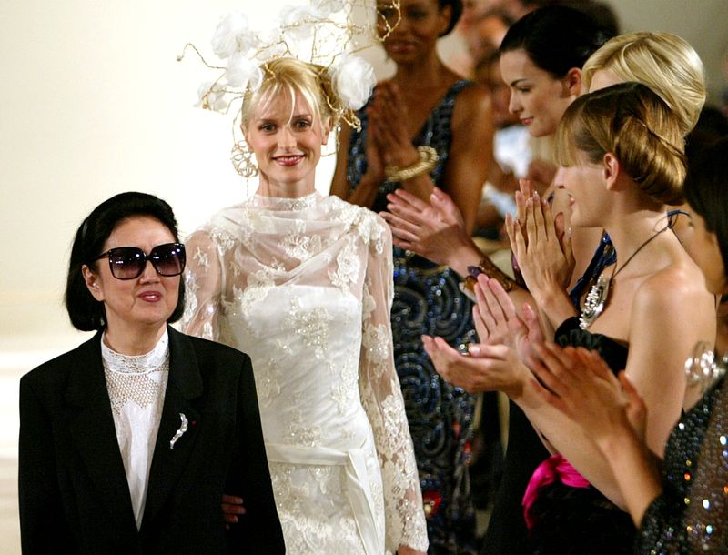 &copy; Reuters. عارضات أزياء يحيين هانا موري مصممة الأزياء اليابانية الرائدة (إلى يسار الصورة) في نهاية عرض لأعمالها في باريس عام 2003. صورة من أرشيف رويترز 