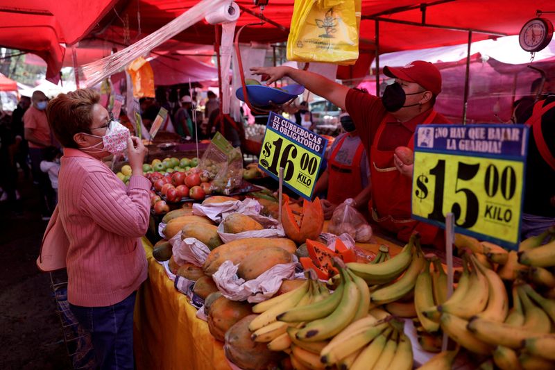 &copy; Reuters. FILE PHOTO: A vendor chats with a customer at a stall in an outdoor market in Mexico City, Mexico January 23, 2022. REUTERS/Luis Cortes/File Photo