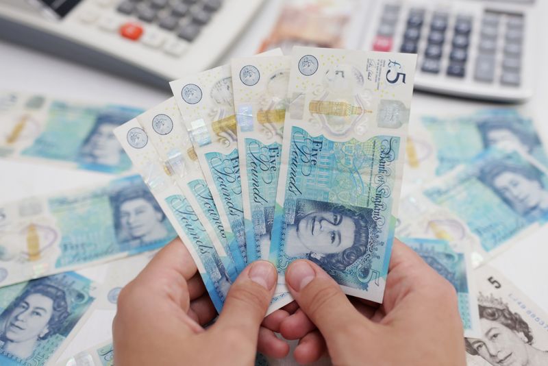 &copy; Reuters. Una donna con diverse banconote da 5 sterline inglesi. REUTERS/Dado Ruvic