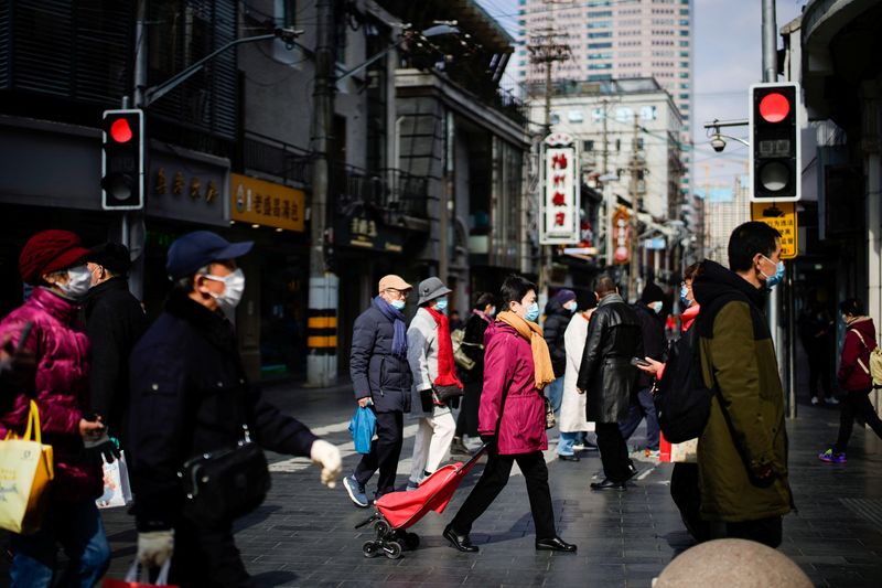 &copy; Reuters. Persone con indosso maschere protettive visitano una delle principali aree commerciali, in seguito a nuovi casi di malattia da coronavirus (COVID-19), a Shanghai, Cina, 21 gennaio 2022. REUTERS/Aly Song