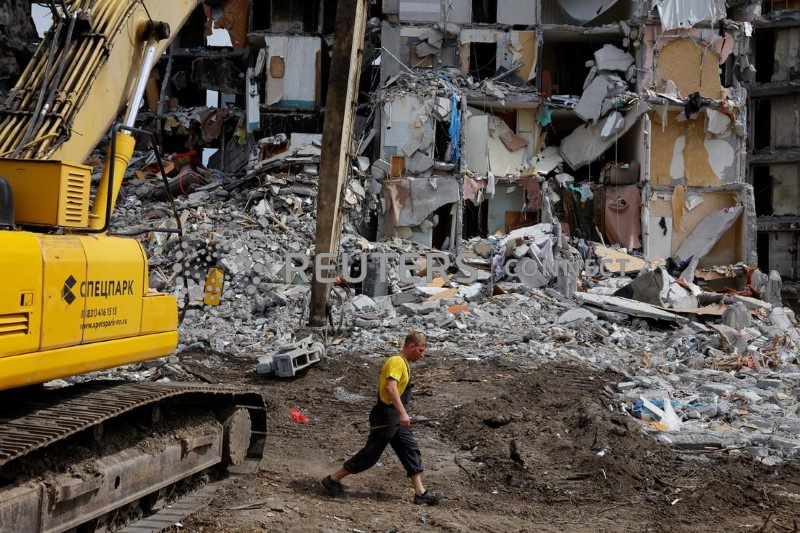 &copy; Reuters. Un operaio cammina davanti a un edificio distrutto, in fase di demolizione, nel corso del conflitto tra Ucraina e Russia nella città portuale meridionale di Mariupol, in Ucraina, il 21 agosto 2022. REUTERS/Alexander Ermochenko