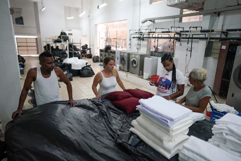 &copy; Reuters. Dalieny Ortega, propietaria de un servicio de lavandería, habla con sus empleados en La Habana, Cuba. 17 de agosto, 2022. REUTERS/Alexandre Meneghini