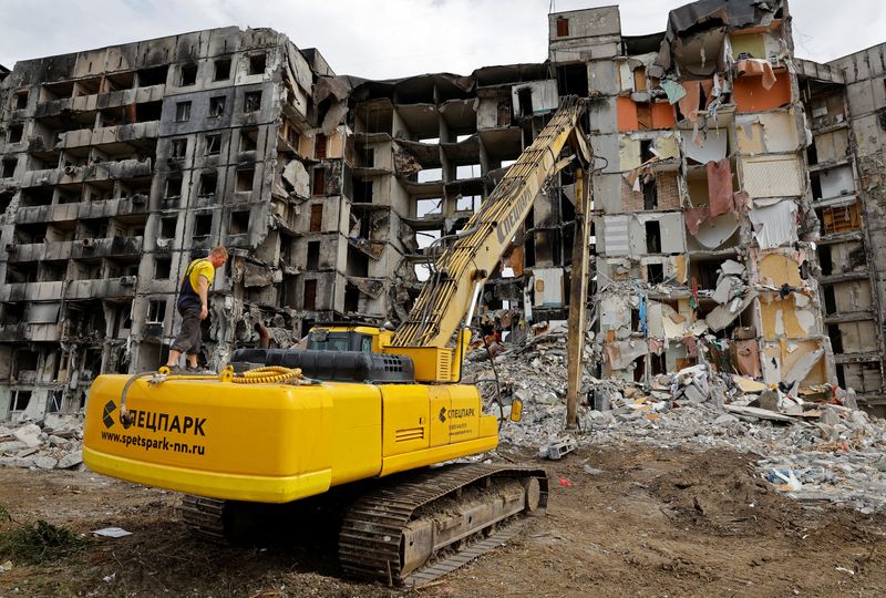 &copy; Reuters. A worker stands on an excavator in front of a destroyed apartment building, that is being demolished, in the course of Ukraine-Russia conflict in the southern port city of Mariupol, Ukraine August 21, 2022. REUTERS/Alexander Ermochenko