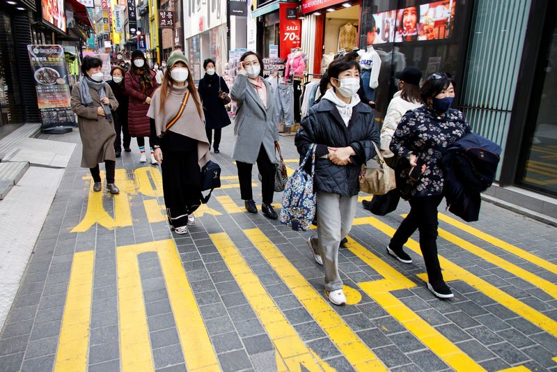 &copy; Reuters. FILE PHOTO: Women wearing masks walk in a shopping district amid the coronavirus disease (COVID-19) pandemic in Seoul, South Korea, November 29, 2021. REUTERS/Heo Ran