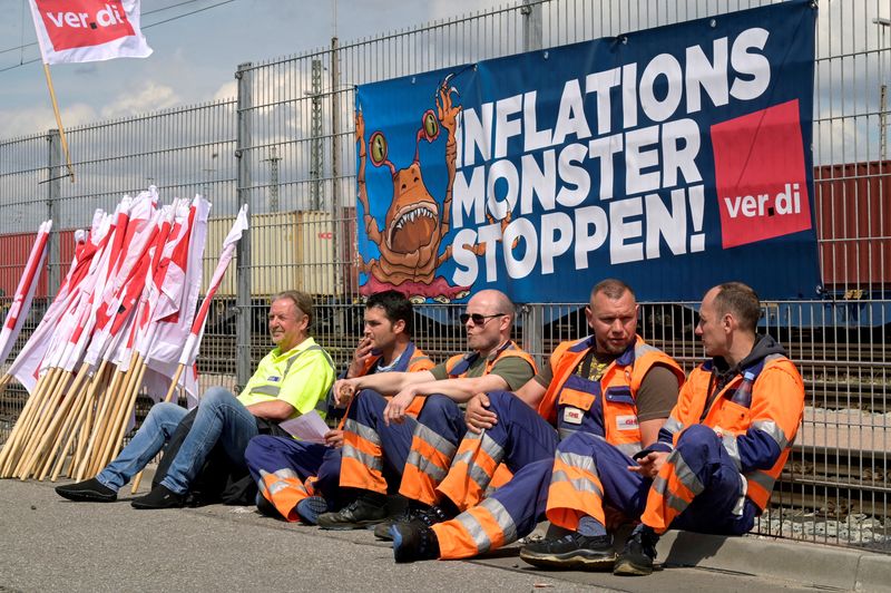 &copy; Reuters. FILE PHOTO: Workers sit in front of a banner reading "Stop the Inflation Monster" at the Burchardkai Container Terminal as they go on strike for higher wages in the harbour in Hamburg, Germany, June 9, 2022. REUTERS/Fabian Bimmer/File Photo