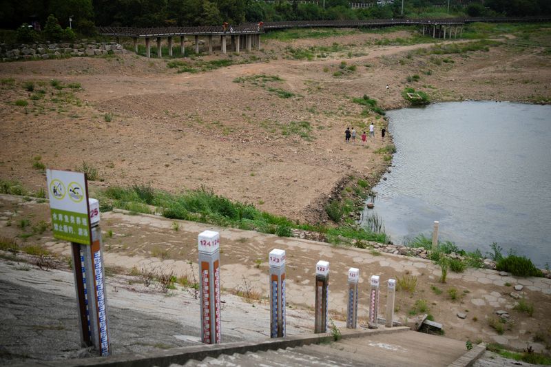 &copy; Reuters. 　８月２３日、中国南西部の重慶市と四川省では、２３日も熱波による火災が続いている。写真は猛暑のなかで水が減って水位計が露出した貯水池。浙江省で２０日撮影（２０２２年　ロイ