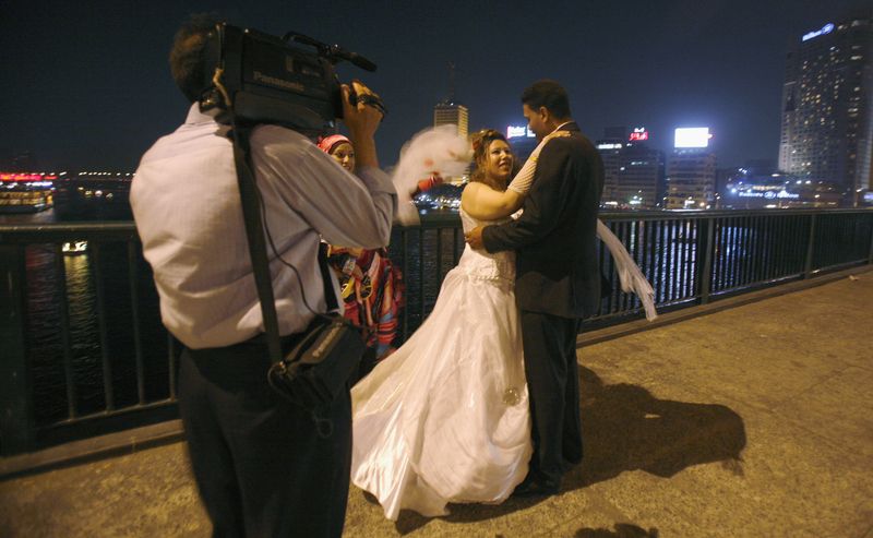 &copy; Reuters. عريس وعروسه يلتقطان صورة فوق جسر السادس من أكتوبر في القاهرة. صورة من أرشيف رويترز
