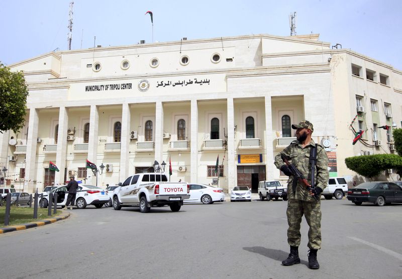 &copy; Reuters. مسلح يحرس مقر بلدية طرابلس في ليبيا. صورة من أرشيف رويترز