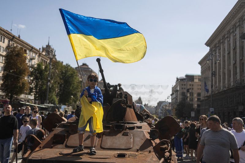 © Reuters. FILE PHOTO: A boy waves a national flag atop of armoured personal carrier at an exhibition of destroyed Russian military vehicles and weapons, dedicated to the upcoming country's Independence Day, amid Russia's attack on Ukraine, in the centre of Kyiv, Ukraine August 21, 2022. REUTERS / Valentyn Ogirenko/File Photo
