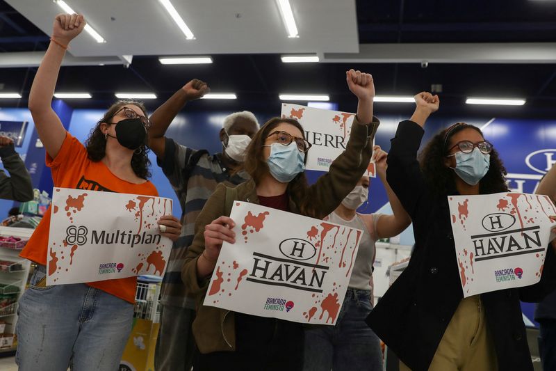 © Reuters. Demonstrators hold signs with the names of companies, inside of a Havan store, owned by Luciano Hang, who was accused by Federal Police of discussing a coup with other Brazilian businessmen in favour of Brazil's President Jair Bolsonaro, in Osasco, Brazil, August 23, 2022. REUTERS/Carla Carniel