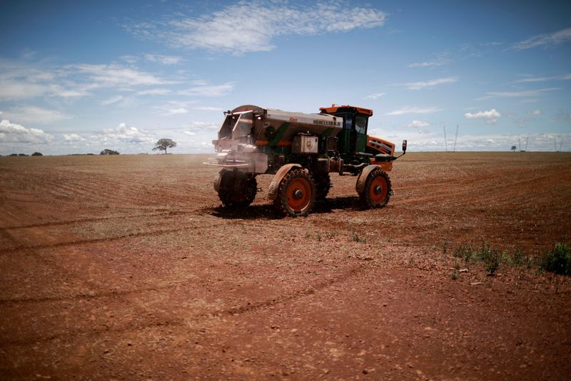 &copy; Reuters. FILE PHOTO: An agricultural worker drives a tractor spreading fertilizer in a soybean field, near Brasilia, Brazil February 15, 2022. REUTERS/Adriano Machado/