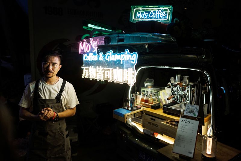 &copy; Reuters. Wang Wei stands next to his coffee bar that he installed in the back of his car at a car boot fair in Beijing, China, August 13, 2022. REUTERS/Thomas Peter