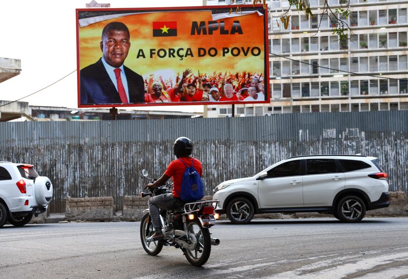 &copy; Reuters. Un motocycliste passe devant un panneau d'affichage avec le visage du président angolais et chef du parti au pouvoir, le MPLA, avant les élections dans la capitale Luanda. Les Angolais sont appelés aux urnes mercredi pour des élections présidentielle