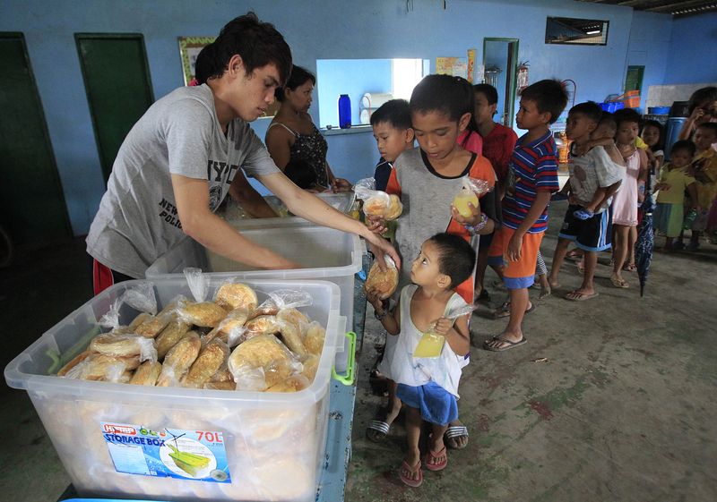 &copy; Reuters. FILE PHOTO: Children queue for a free meal during a feeding program by outreach group World Mission Community Care, at a slum area in the Baseco compound, metro Manila July 30, 2014. REUTERS/Romeo Ranoco