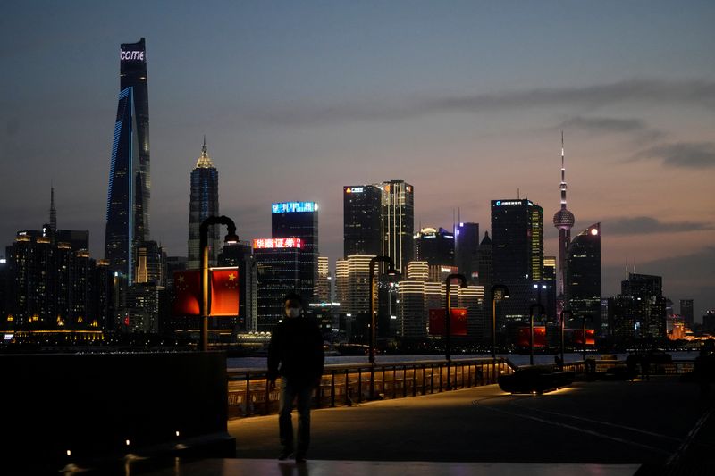 &copy; Reuters. FILE PHOTO: A man walks in front of Lujiazui financial district, seen across the Huangpu river at dusk, amid the lockdown in Pudong area to contain the spread of the coronavirus disease (COVID-19) in Shanghai, China March 28, 2022. REUTERS/Aly Song