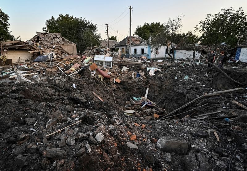 &copy; Reuters. People stand next to a residential house destroyed by a Russian military strike, as Russia's attack on Ukraine continues, in Chaplyne, Dnipropetrovsk region, Ukraine August 24, 2022.  REUTERS/Dmytro Smolienko