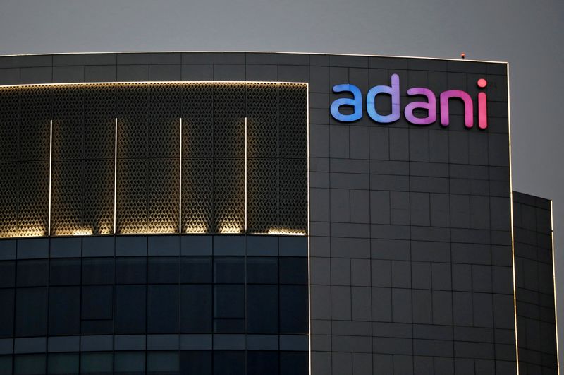 © Reuters. FILE PHOTO: The logo of the Adani Group is seen on the facade of one of its buildings on the outskirts of Ahmedabad, India, April 13, 2021. REUTERS/Amit Dave