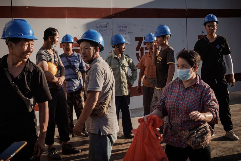 &copy; Reuters. FILE PHOTO: Workers leave the construction site of the new Workers' Stadium in Beijing, China, July 28, 2022. REUTERS/Thomas Peter