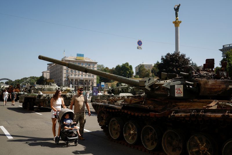 &copy; Reuters. A couple with a child visit an exhibition of destroyed Russian military vehicles and weapons, dedicated to the country's Independence Day, amid Russia's attack on Ukraine, in the centre of Kyiv, Ukraine August 24, 2022. REUTERS / Valentyn Ogirenko