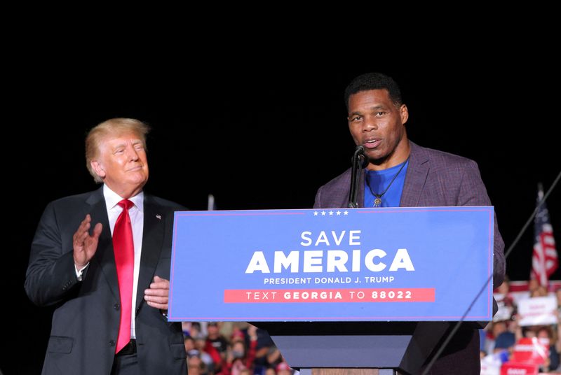 &copy; Reuters. FILE PHOTO: Former college football star and current senatorial candidate Herschel Walker speaks at a rally, as former U.S. President Donald Trump applauds, in Perry, Georgia, U.S. September 25, 2021. REUTERS/Dustin Chambers/File Photo