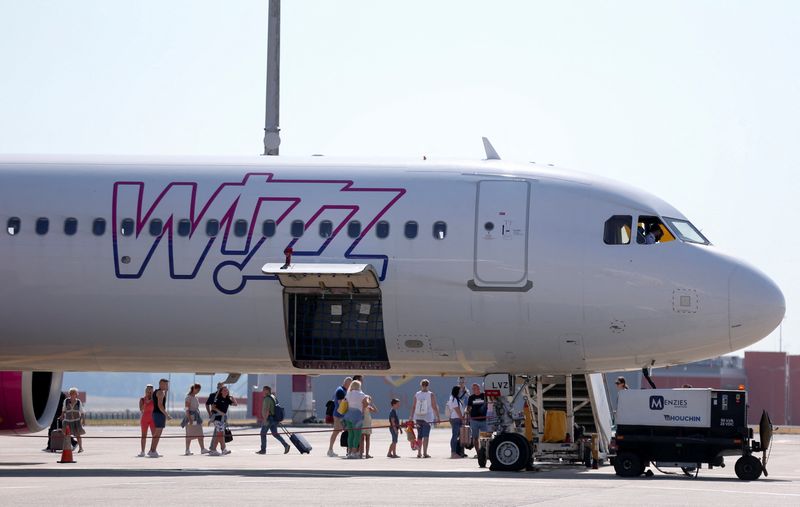 &copy; Reuters. FILE PHOTO: People stand next to a Wizz Air aircraft at Ferenc Liszt International Airport in Budapest, Hungary, August 18, 2022. REUTERS/Bernadett Szabo