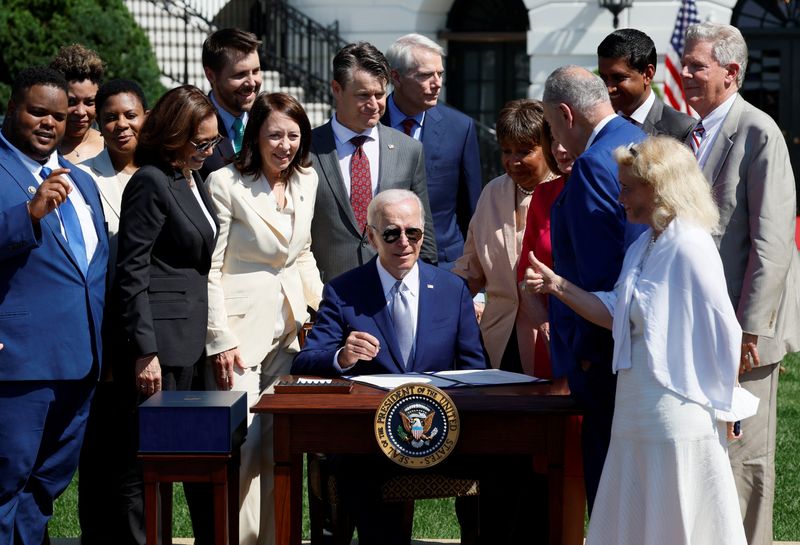 &copy; Reuters. U.S. President Joe Biden signs the CHIPS and Science Act of 2022 alongside Vice President Kamala Harris, House of Representatives Speaker Nancy Pelosi and Joshua Aviv, founder and CEO of SparkCharge, on the South Lawn of the White House in Washington, U.S